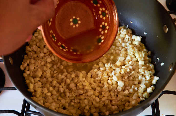 Adding Chicken or Vegetable Broth to Corn Kernels in Pan