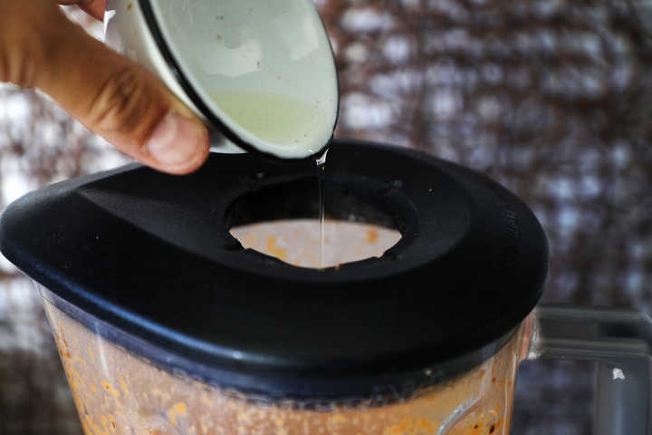 Adding oil to blender jar.