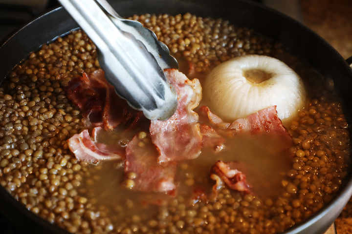 Adding Bacon to Lentil Soup Cooking on Stove