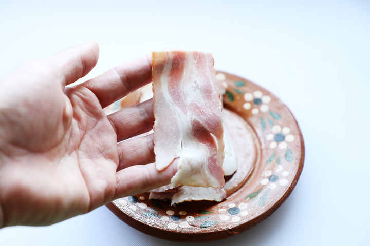 Strip of Bacon in Cook's Hand