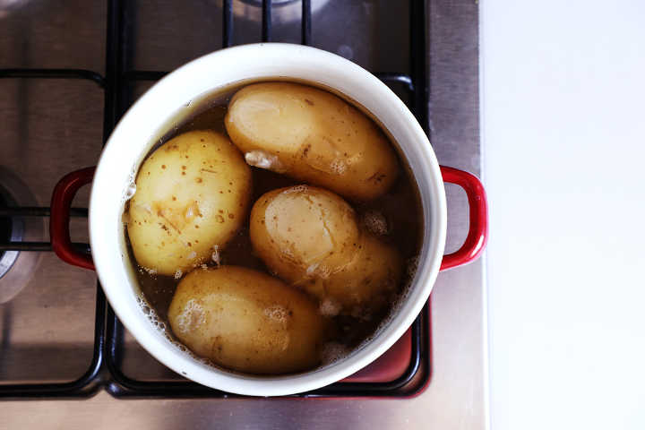 Boiled waxy potatoes in pot.