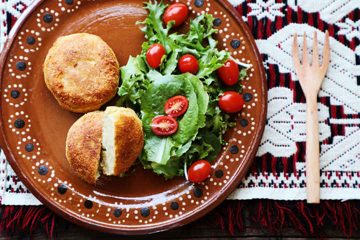 Mexican croquetas de papa served with a green salad.
