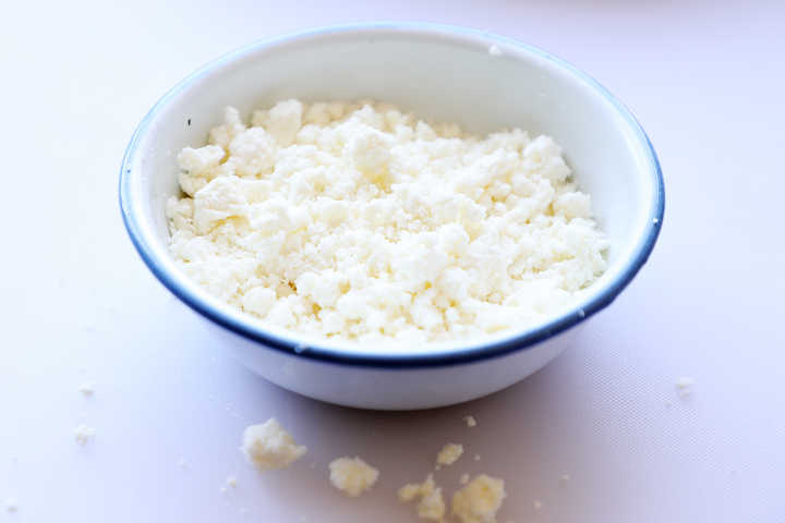 Crumbled Mexican cheese in small bowl.