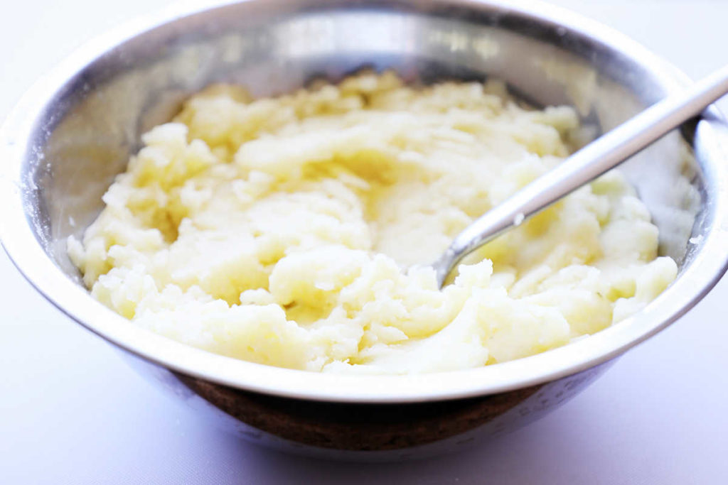 Mashed potatoes in small mixing bowl.