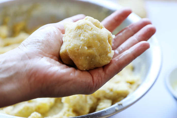 Ball of potato, egg, cheese mixture in hand.