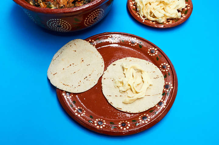 Tortilla and cheese on plate to make quesadillas.