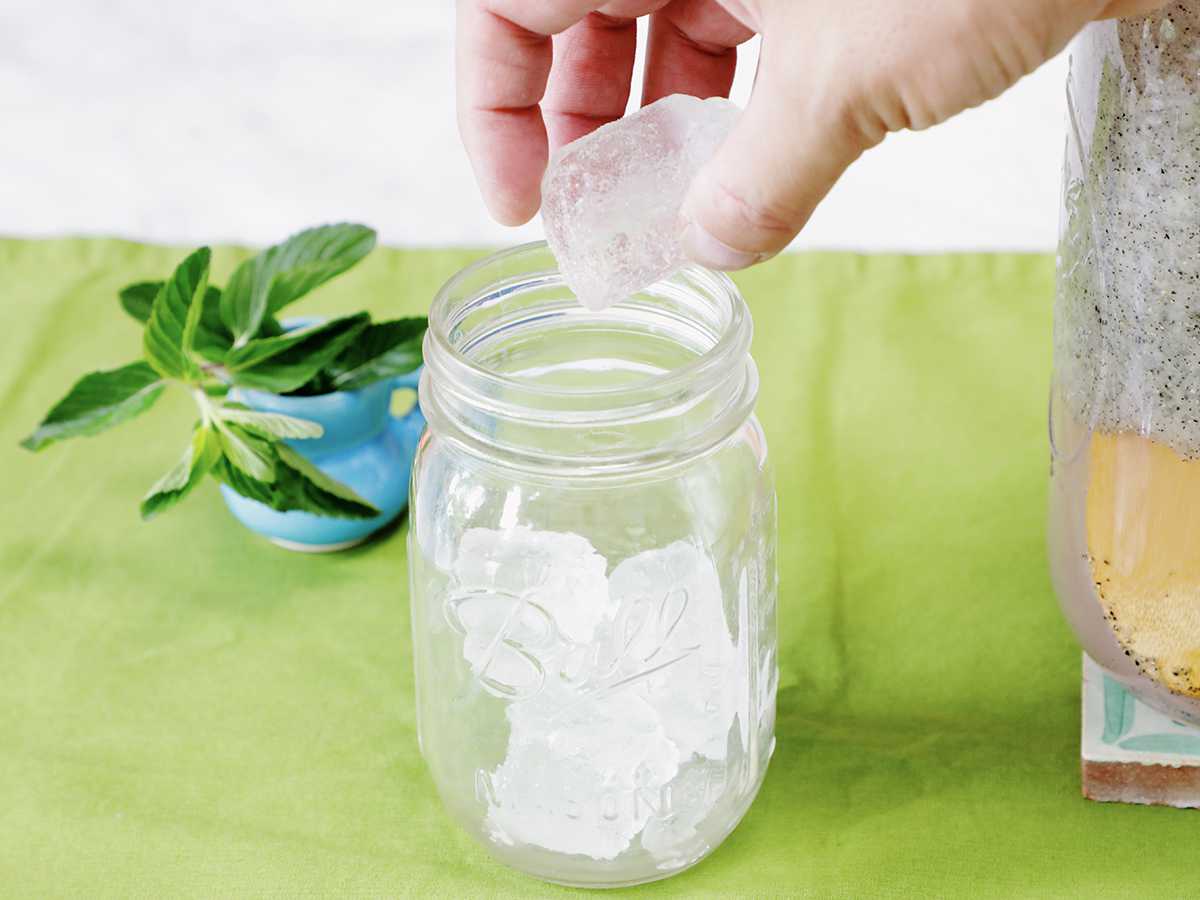 Filling a glass jar with ice.