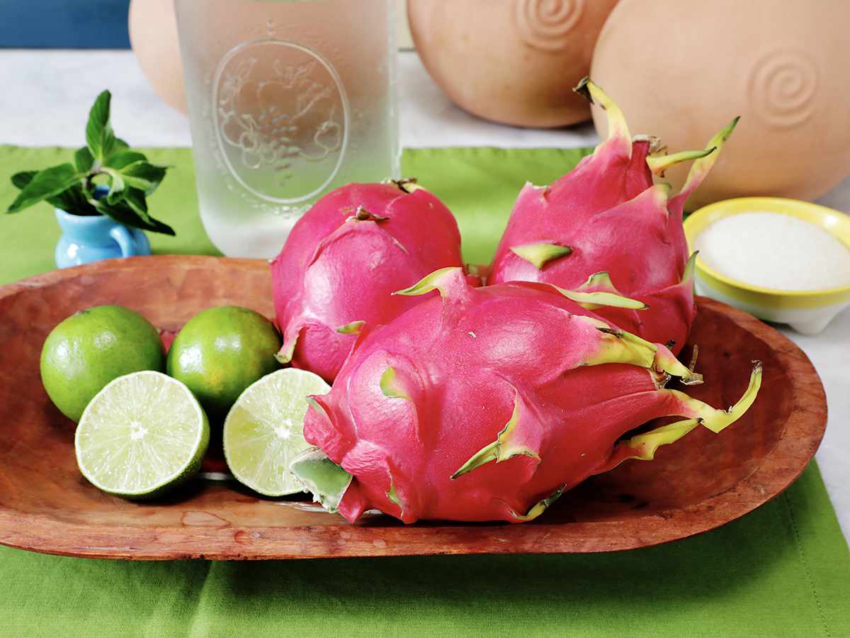 Ingredients to make dragon fruit agua fresca on wooden tray.