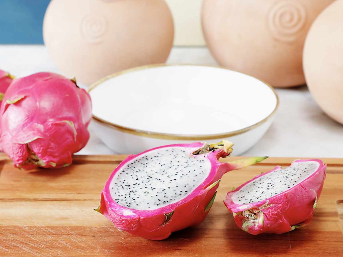 Sliced dragon fruit on wooden cutting board.